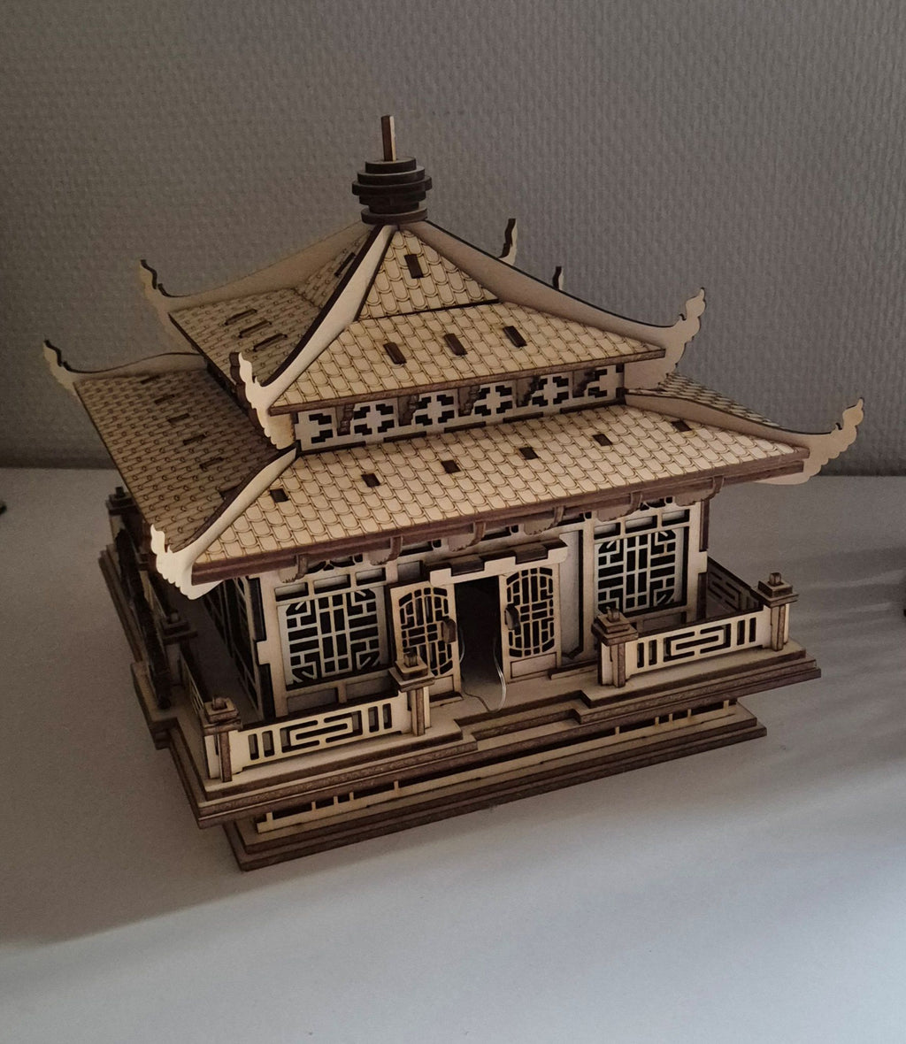 Laserskåret asiatisk tempel i træ set fra siden med detaljerede tagetager